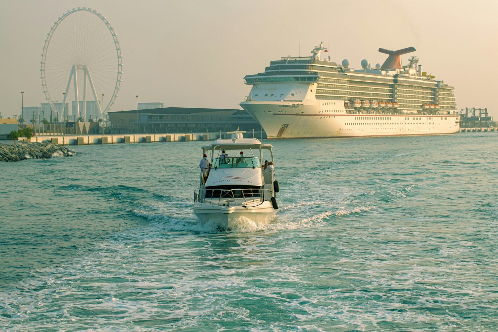 a small boat in the water with a large cruise ship in the background